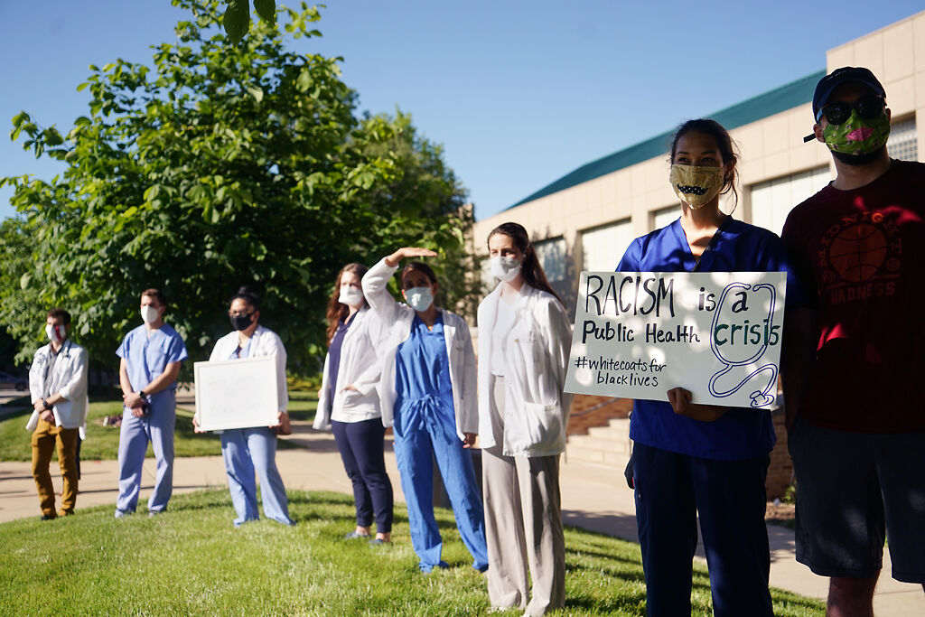 Health care professionals wait for speeches during the moment of silence demonstration